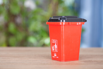 A model of a red classified hazardous waste bin on the table