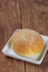 Bread bun on a white plate.