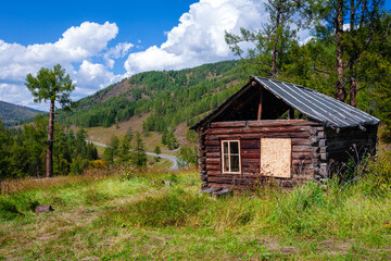 Beautiful wooden abandoned log house on mountains background