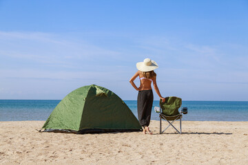 journey to the sea. camping on the beach. Vacation by the water. Men and a tent with a tourist chair on the sand