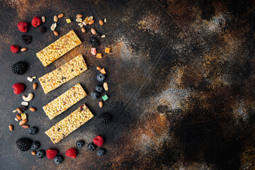 Raw organic granola bars with seeds and nuts, top view with copy space, on old dark table