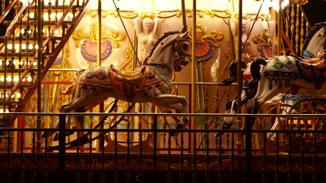Horses inside moving Carousel, roundabout or merry-go-round surround with colorful lights