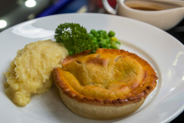 Meat pie with potato mash, peas and gravy