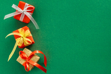 Festive banner with bright multicolored gifts on a green background to the left. Copy space.Top view.