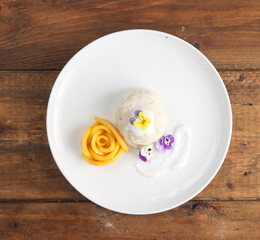 Mango Sticky Rice, delicious thai dessert from mango and sticky rice with coconut milk sauce, topping with viola edible flower.