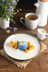 Mango Sticky Rice, delicious thai dessert from mango and sticky rice with coconut milk sauce, topping with viola edible flower.