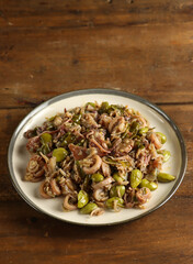 Spicy stir fried salted squid with pete known as tumis cumi asin pedas dengan pete or sambal cumi asin pete in Indonesia.
