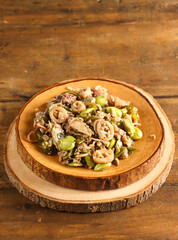 Spicy stir fried salted squid with pete known as tumis cumi asin pedas dengan pete or sambal cumi asin pete in Indonesia.