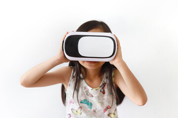Portrait of a cute little Asian girl using a VR headset, standing against a white background