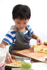 Portrait cute little Asian boy interested in the baking bakery at home kitchen
