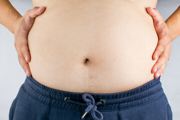 Overweight Asian man holding his belly. Belly fat, overweight and diet concept.