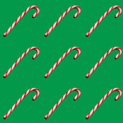 Seamless pattern with Christmas candy on green background.