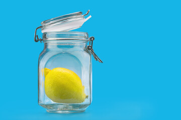 glass jar with lemon inside, on a blue background