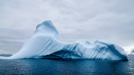 Icebergs and snow capped mountains in the Antarctic Peninsula after passing the Lemaire Channel in...