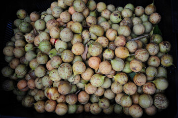 Top view fresh raw nutmeg fruits on a market stall