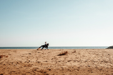 Woman riding a horse in a dunes beach