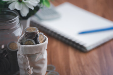 coin purse, calculator, book, and pens are all placed on the wooden table.