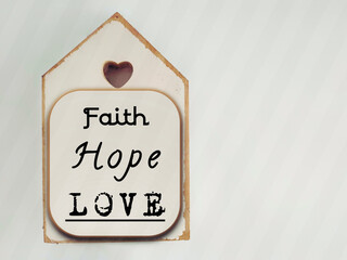 Inspirational concept - faith, hope, love text written on wooden frame background. Stock photo. 