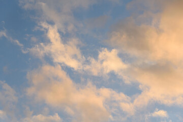 Colorful blue sky and clouds highlighted by setting sun, as a nature background
