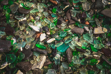 Natural background with sea glass close-up on sand.