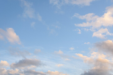 Colorful blue sky and clouds highlighted by setting sun, as a nature background
