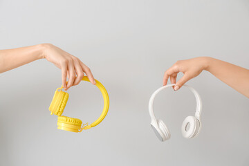 Female hands with headphones on white background