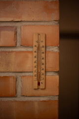 Wooden thermometer on a brick wall