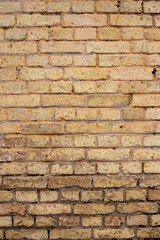 A wall of old yellow and brown bricks.
