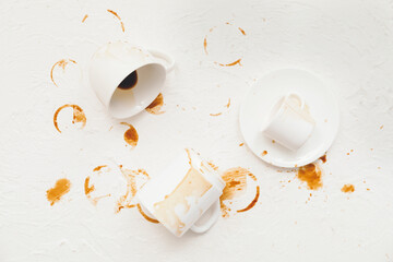 Cups and coffee stain on light background