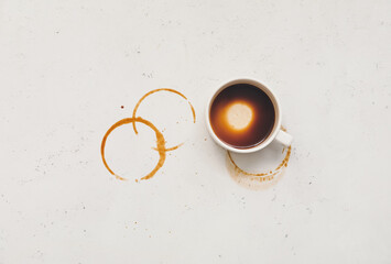 Cup and coffee stain on light background