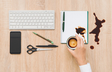 Woman with spilling cup of coffee on wooden table