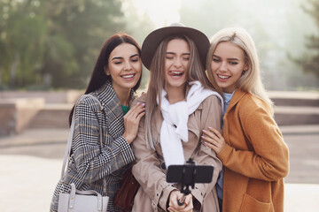 Beautiful young women taking selfie outdoors