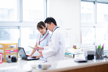 同僚の看護士から報告を受ける医師