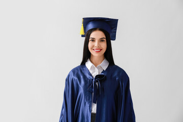 Female graduating student on light background