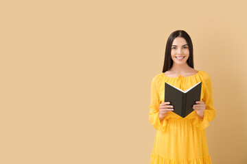 Young woman reading book on color background