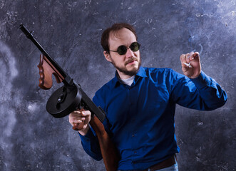 Mature man in sunglasses with tommy gun