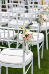 Outdoor wedding venue chairs with flower and ribbon decoration