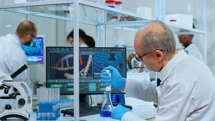 Close up of man scientist using micropipette in modern equipped laboratory. Multiethnic team examining vaccine evolution with high tech and chemistry tools for research in development of covid19 virus