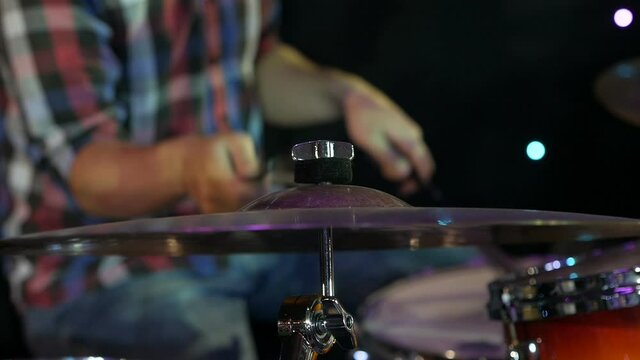 guy plays a musical instrument plates. Has drum sticks on installing.