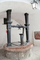 Medieval well in the courtyard of the castle. Stone well with wooden posts