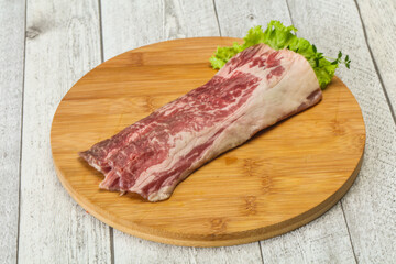 Raw beef bacon over wooden board