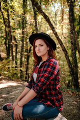 Fototapeta na wymiar traveler hipster woman standing alone in autumn woods .