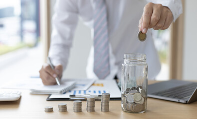 Financial business man with coins put in a jar.