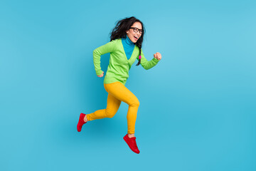 Full size profile side photo of brown messy pigtail haired woman jump run empty space isolated on blue color background