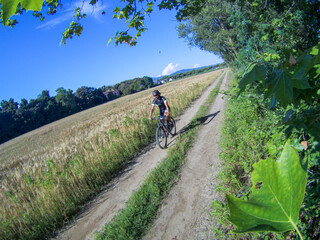 Fototapeta premium A biker on the classic white road of Tuscany in an autumnal sunny day