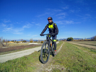 Fototapeta na wymiar A mountain biker on the Giacomo Puccini cycle path along Serchio river