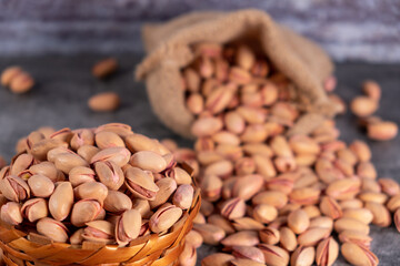 Dried pistachios in small sack on  table.