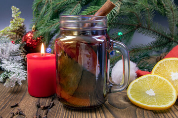view of a cup of Christmas hot mulled wine, with spices and fruits on a wooden rustic table...