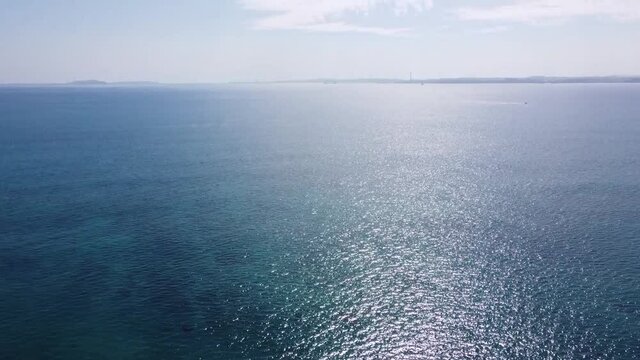 ドローンで撮影した青い海から空へのパンアップ動画