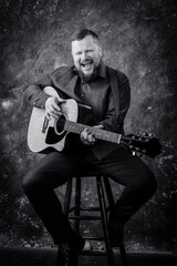 Obraz premium Mature musician plays acoustic guitar emotional studio portrait.